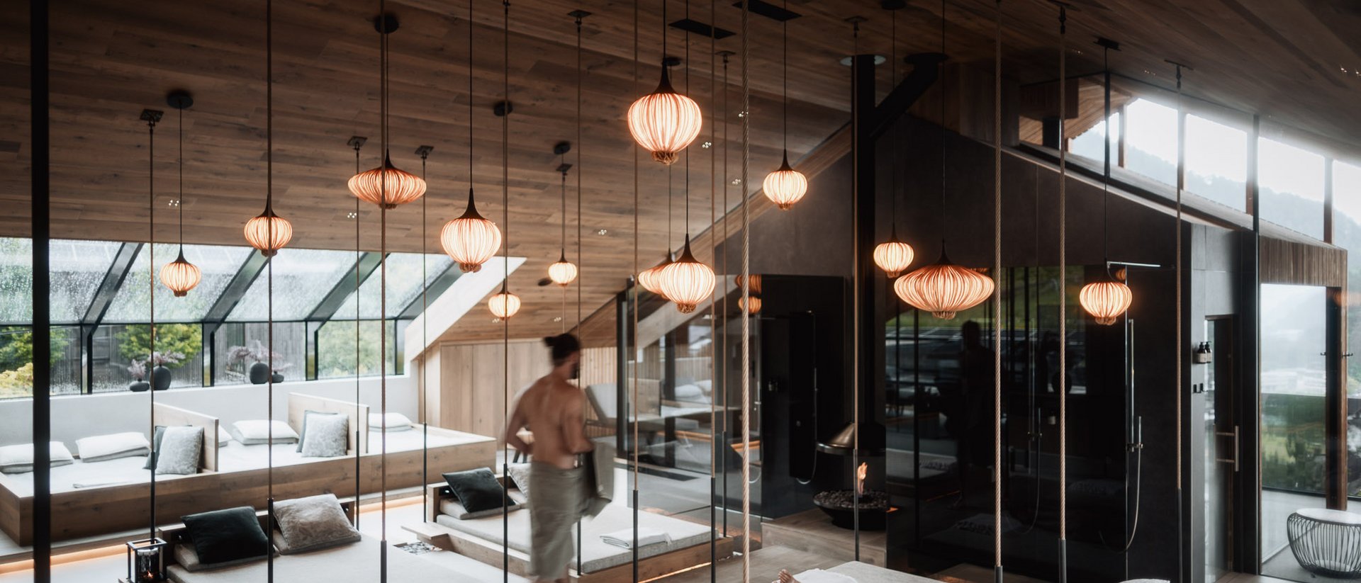 Erfüllender Urlaub in Ihrem Luxus-Chalet in Südtirol Moderne Spa-Lounge mit hängenden Lampen und entspannenden Gästen