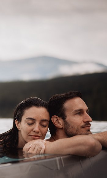 Your hotels in South Tyrol: the home of abundance Couple relaxing in pool with mountain view in background