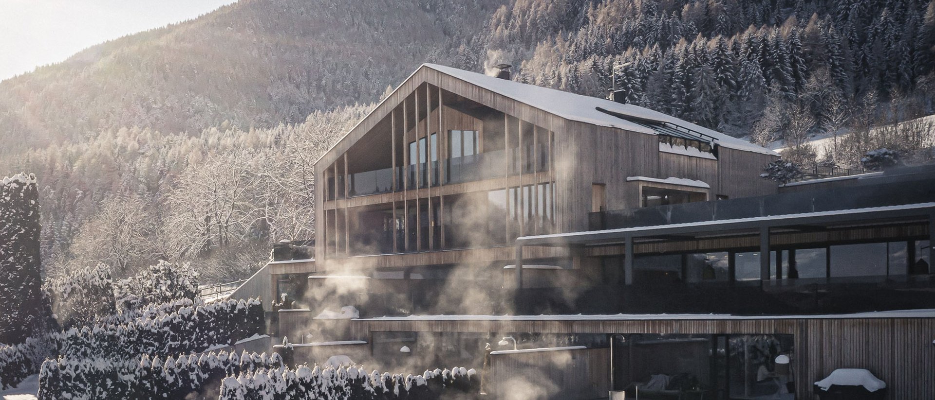 Erfüllender Urlaub in Ihrem Luxus-Chalet in Südtirol Modernes Holzhaus mit Schnee und Nebel vor bewaldetem Berg