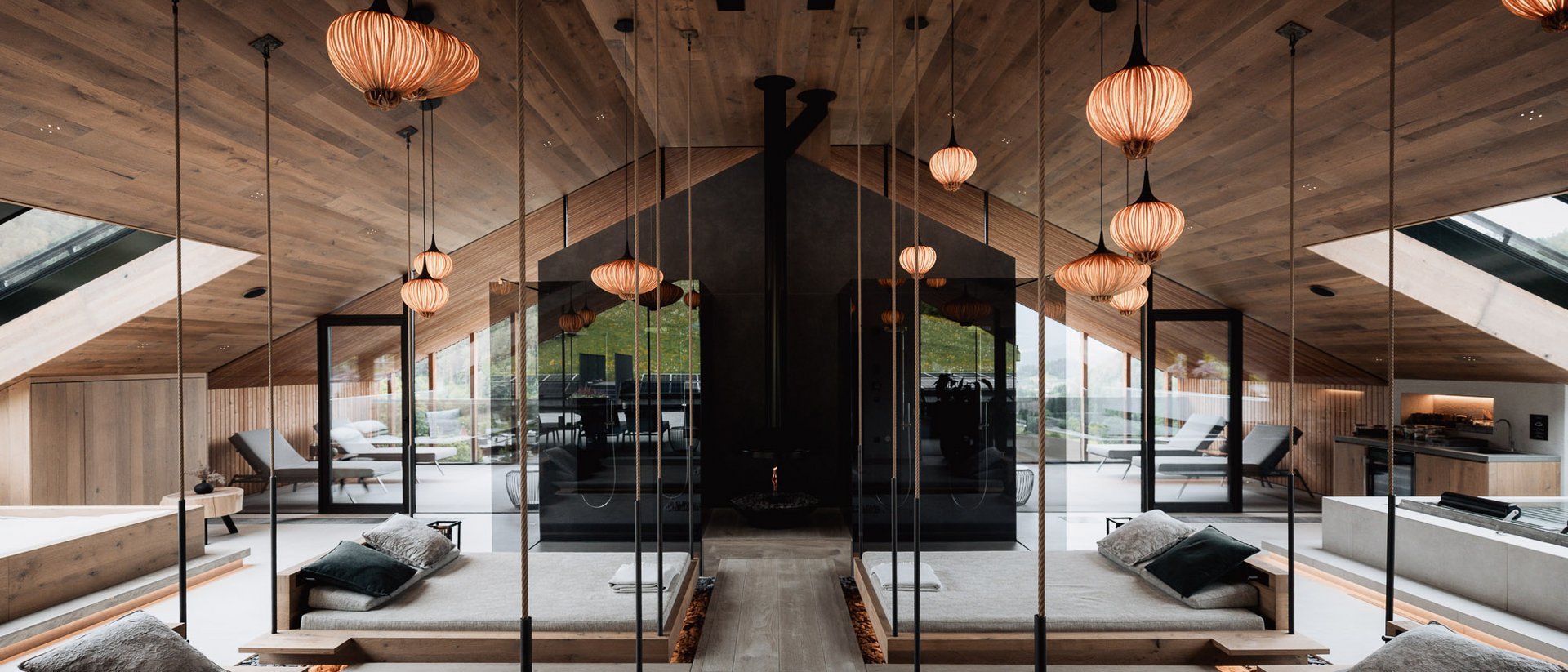 Erfüllender Urlaub in Ihrem Luxus-Chalet in Südtirol Modernes Spa mit hängenden Betten, Spiegeln und warmen Holzakzenten