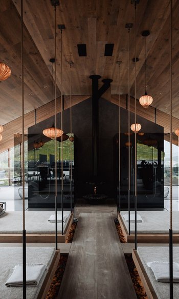 Erfüllender Urlaub in Ihrem Luxus-Chalet in Südtirol Modernes Spa mit hängenden Betten, Spiegeln und warmen Holzakzenten