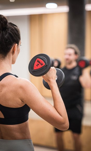 Your hotels in South Tyrol: the home of abundance People lifting weights in front of a mirror in a gym