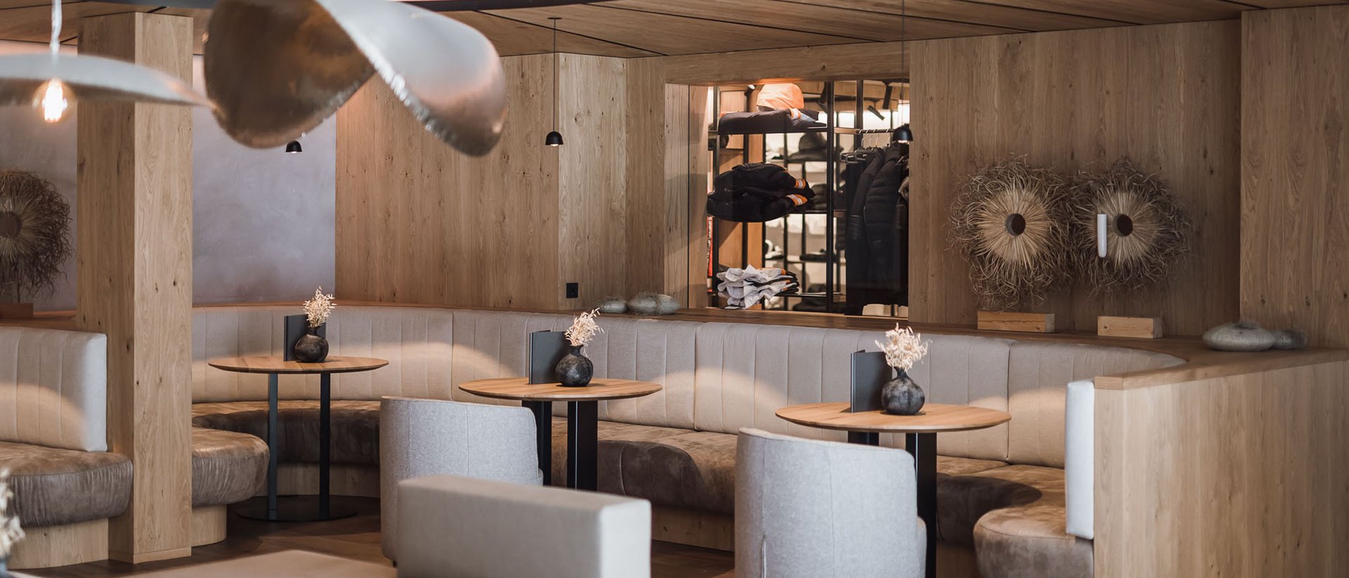 Die Quelle der Erfüllung: Ihr Hotel am Kronplatz Modernes gemütliches Café mit Sitznischen und Holzakzenten