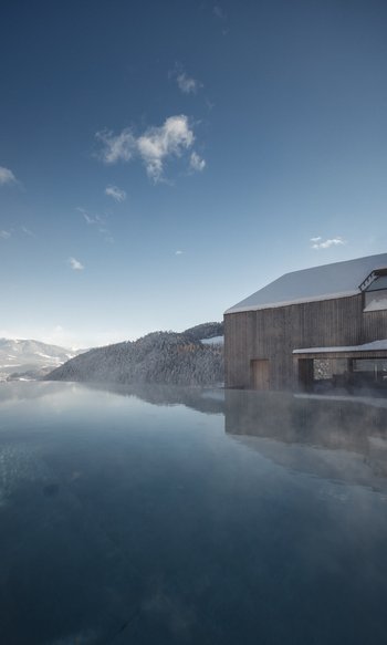 Erfüllender Urlaub in Ihrem Luxus-Chalet in Südtirol Außenpool mit Nebel vor einem Haus in schneebedeckter Berglandschaft