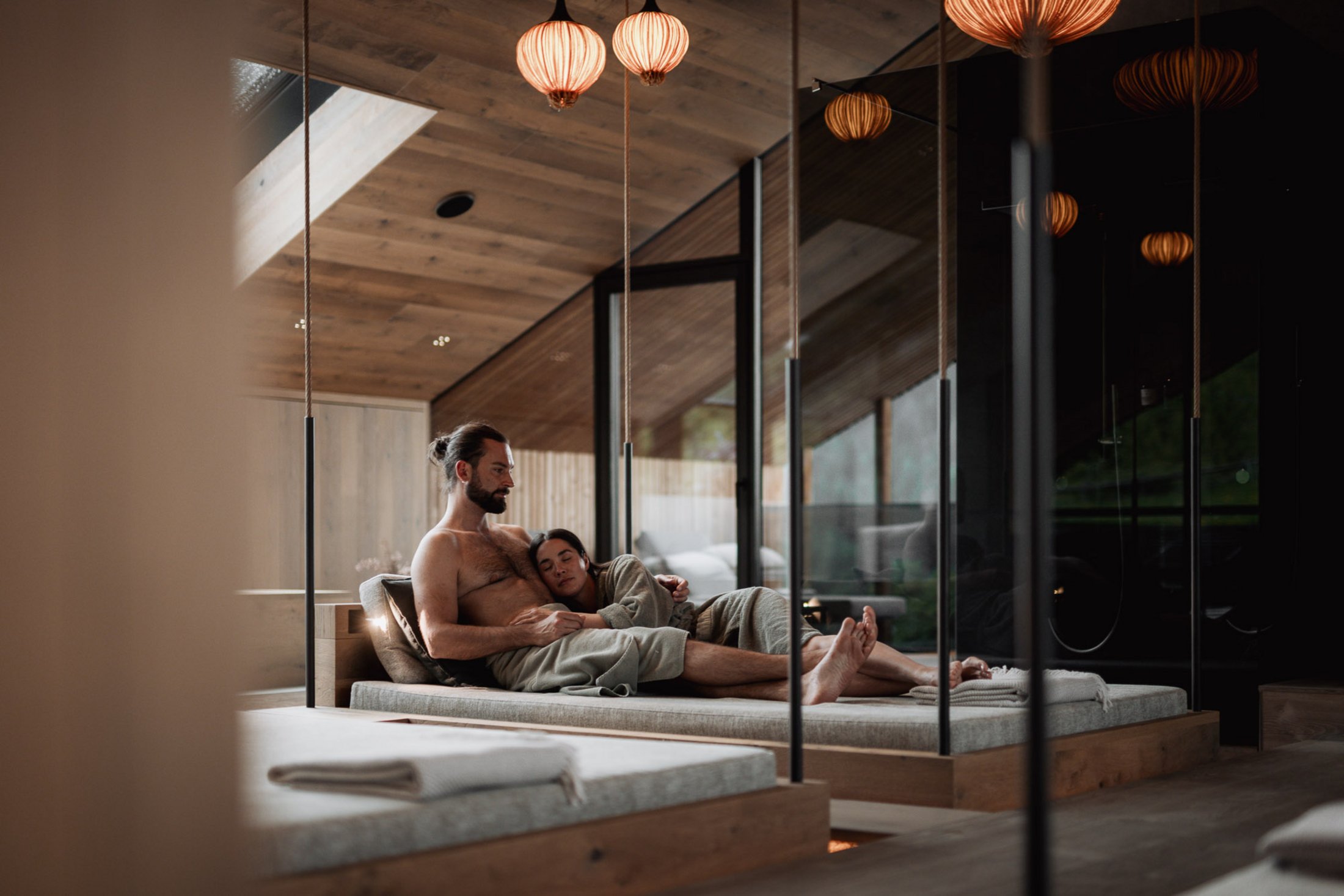 Erfüllender Urlaub in Ihrem Luxus-Chalet in Südtirol Paar entspannt sich gemeinsam in einem modernen Spa mit Holzelementen