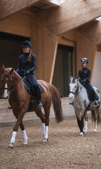 Your hotels in South Tyrol: the home of abundance Horse riding lesson with three children on horses and an instructor in an indoor arena