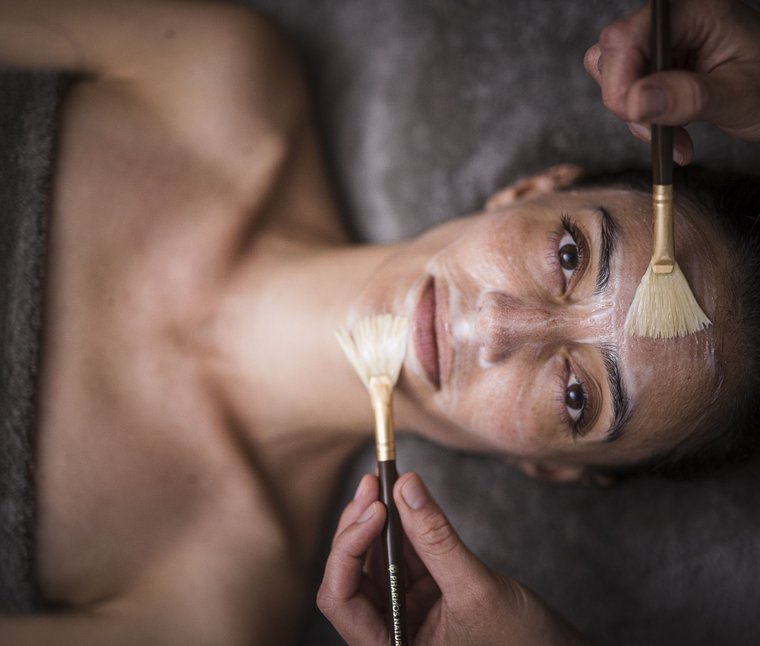 Ihre Hotels in Südtirol: die Heimat der Fülle Frau erhält Gesichtsmaske mit Pinseln im Spa