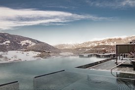 Ihre Hotels in Südtirol: die Heimat der Fülle Infinity-Pool mit Winterlandschaft und Bergen im Hintergrund