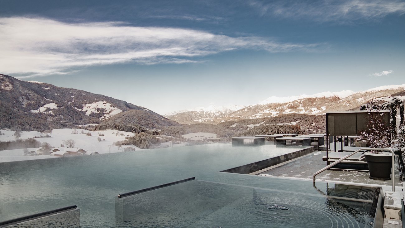 Ihre Hotels in Südtirol: die Heimat der Fülle Infinity-Pool mit Winterlandschaft und Bergen im Hintergrund