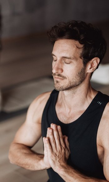 Ihre Hotels in Südtirol: die Heimat der Fülle Mann und Frau meditieren zusammen mit geschlossenen Augen und gefalteten Händen