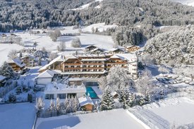Ihre Hotels in Südtirol: die Heimat der Fülle Hotel in verschneiter Berglandschaft mit umliegenden Bäumen und Feldern