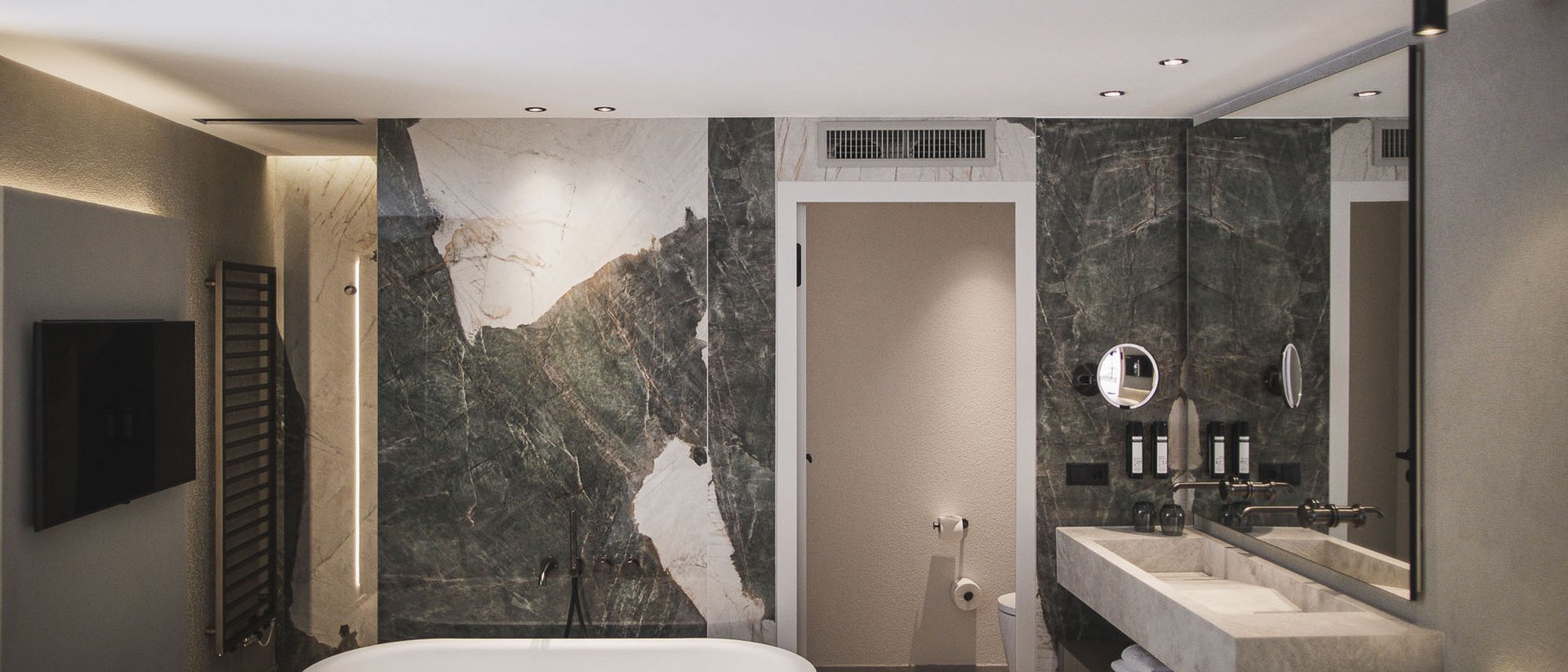 Der Ursprung des Wohlgefühls: Ihr Hotel im Pustertal Modernes Badezimmer mit freistehender Badewanne und Marmorwand