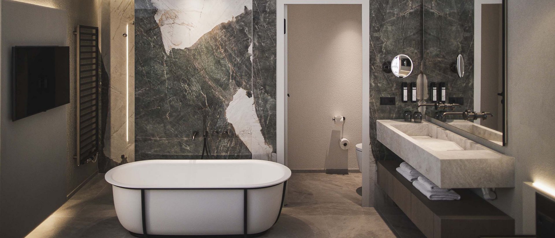 Der Ursprung des Wohlgefühls: Ihr Hotel im Pustertal Modernes Badezimmer mit freistehender Badewanne und doppelseitigem Waschbecken