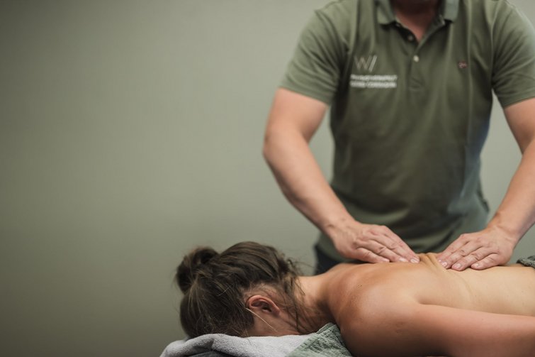 Der Ursprung des Wohlgefühls: Ihr Hotel im Pustertal Person erhält Rückenmassage von Masseur in grünem Polohemd