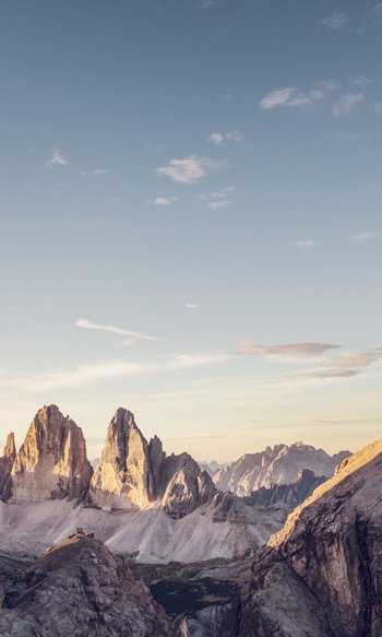 Ihre Hotels in Südtirol: die Heimat der Fülle Blick auf die Dolomiten mit Felsen im Sonnenlicht bei klarem Himmel