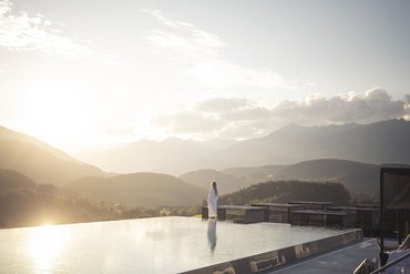 Ihre Hotels in Südtirol: die Heimat der Fülle Person im Bademantel am Infinity-Pool bei Sonnenuntergang mit Bergblick