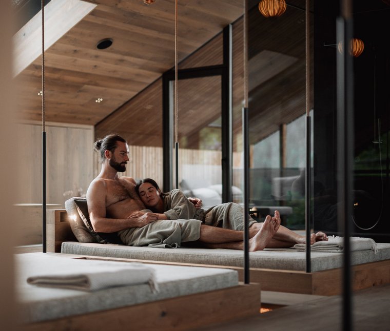 Ihre Hotels in Südtirol: die Heimat der Fülle Paar entspannt sich gemeinsam in einem modernen Spa mit Holzelementen