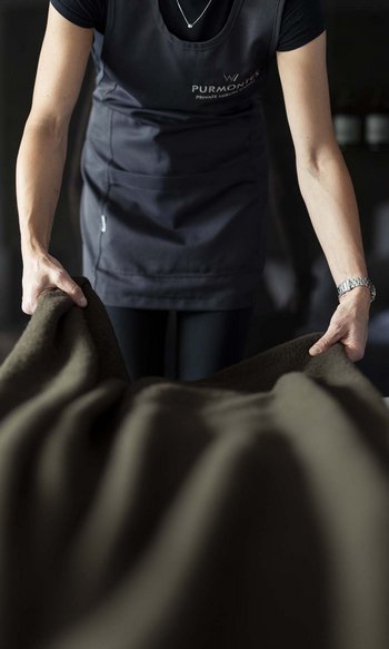 Ihre Hotels in Südtirol: die Heimat der Fülle Person breitet Bettdecke in dunklem Raum aus